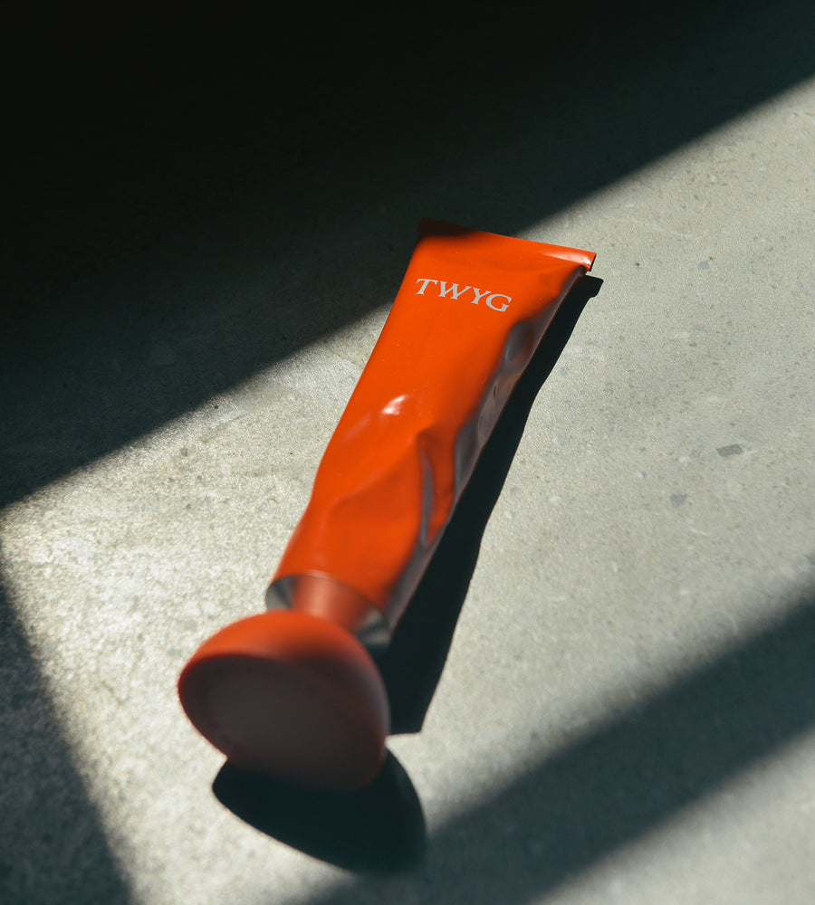 Orange tool with 'TWYG' branding on a concrete surface