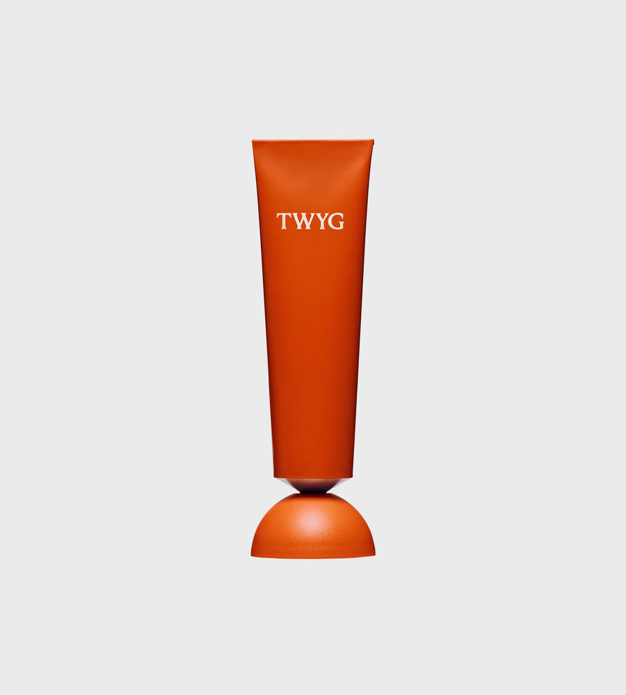 Orange tube with 'TWYG' branding on a light gray background
