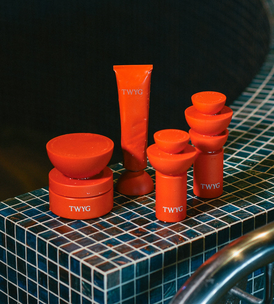 Collection of TWYG products on a tiled surface with a dark background