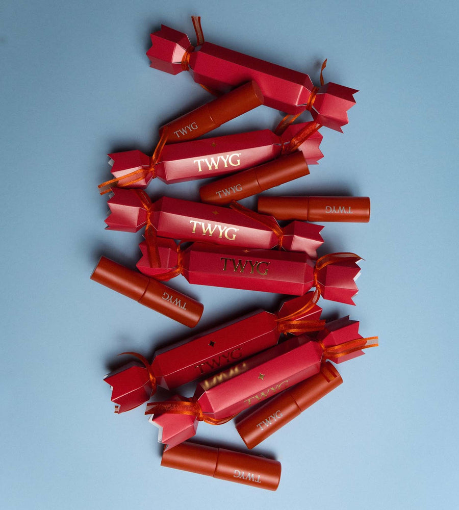 Red lipsticks with 'TWYG' branding on a blue background