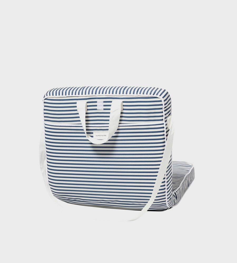 Blue and white striped bag with a white strap on a light gray background