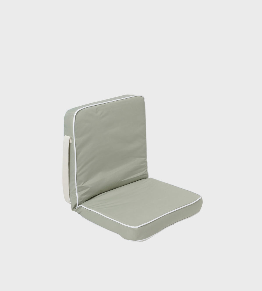 Light gray cushion with white piping on a white background
