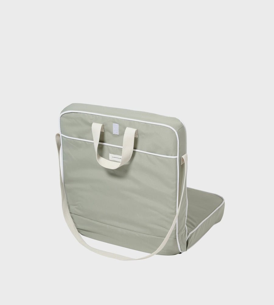 Green folding table with carrying strap on a light gray background