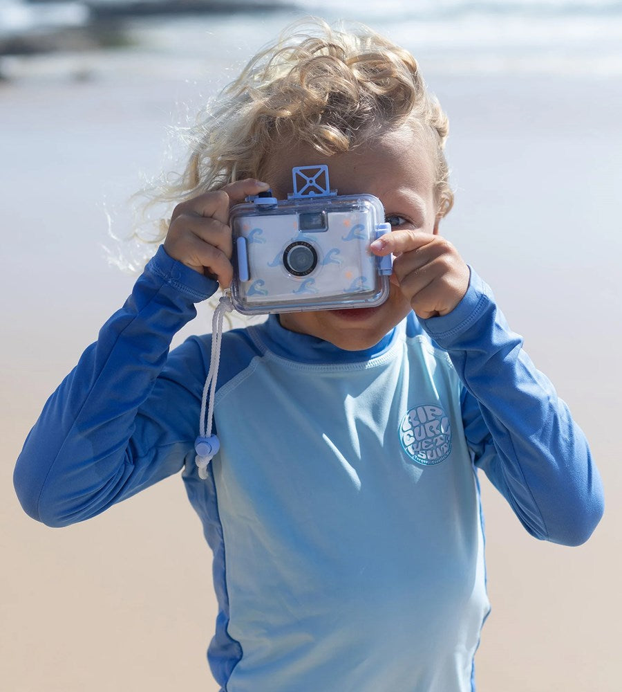 Child holding a waterproof camera on a beach