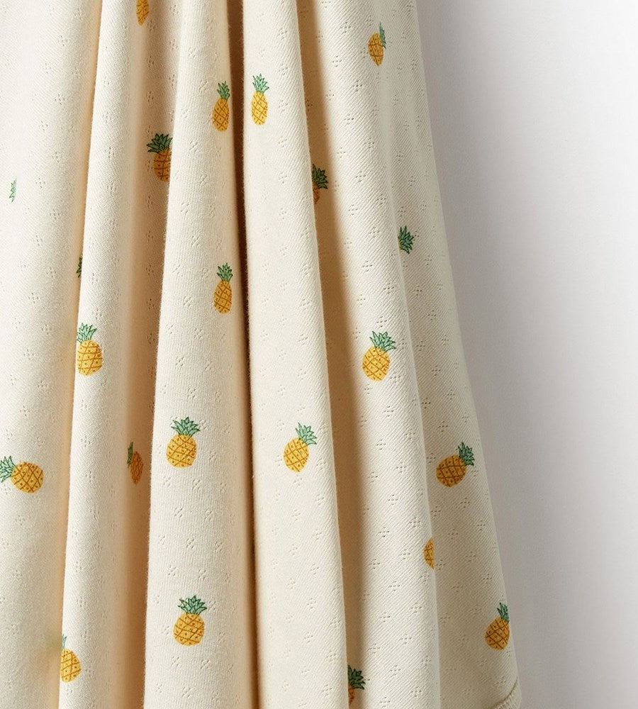 Beige curtain with pineapple patterns on a plain background
