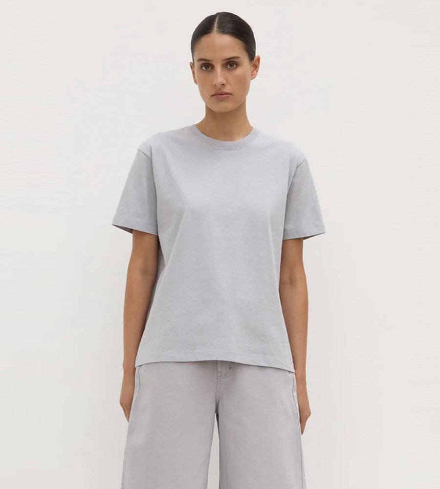 Person wearing a light gray t-shirt and pants on a plain background