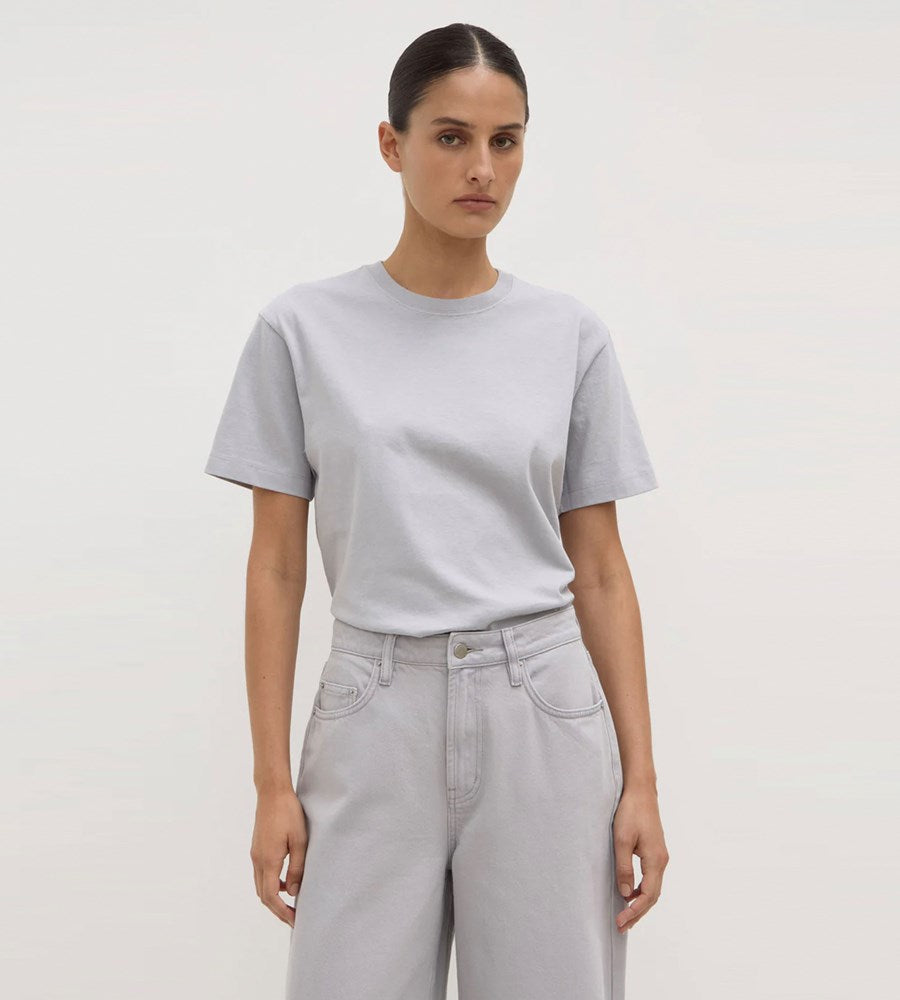 Person wearing a light gray t-shirt and pants on a plain background