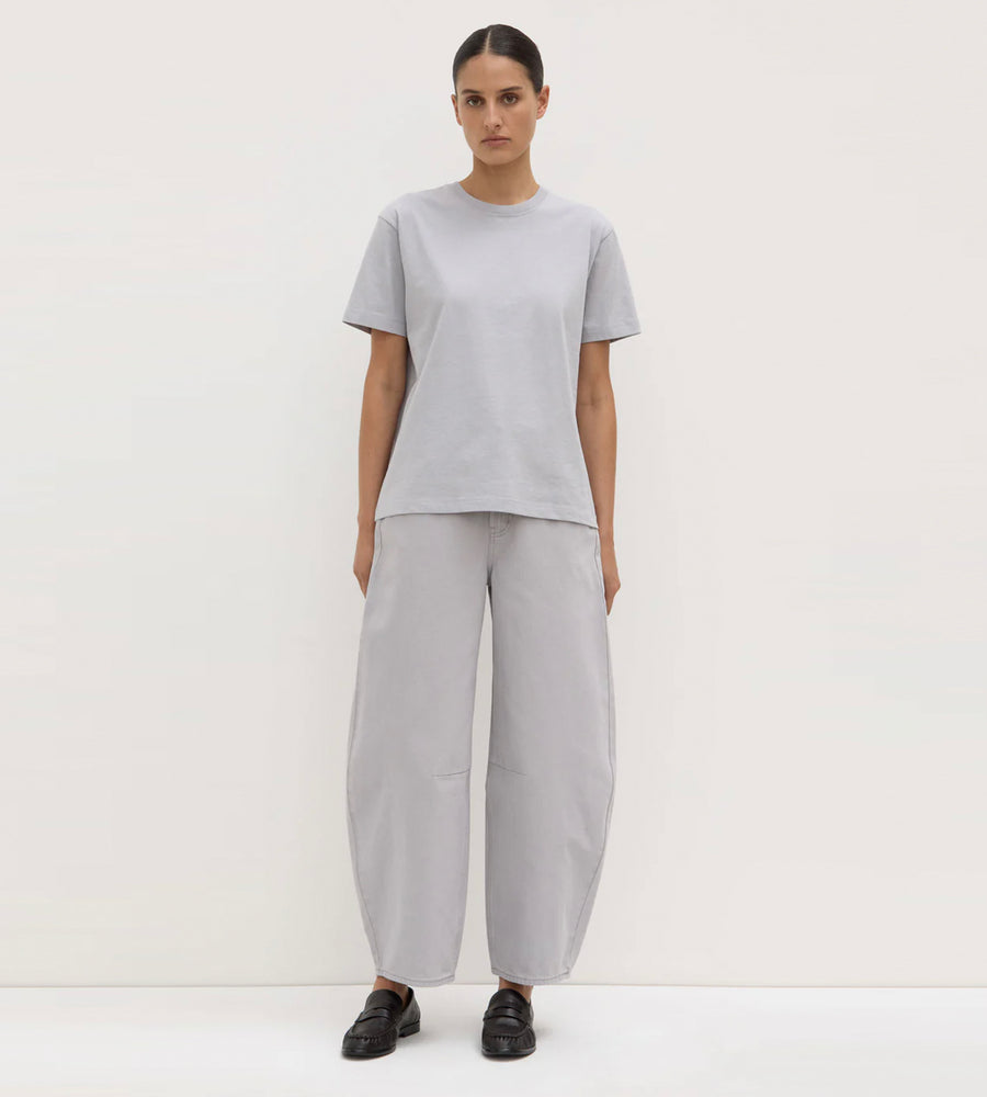 Person wearing a gray outfit with wide-leg pants on a white background