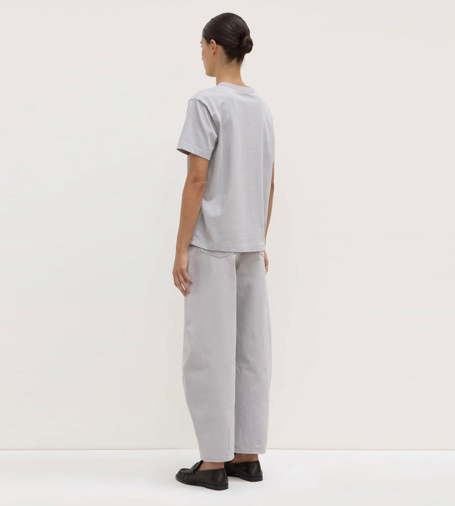 Person wearing a gray t-shirt and pants on a white background