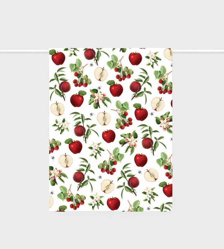 Tea towel with red apples and green leaves pattern on a white background