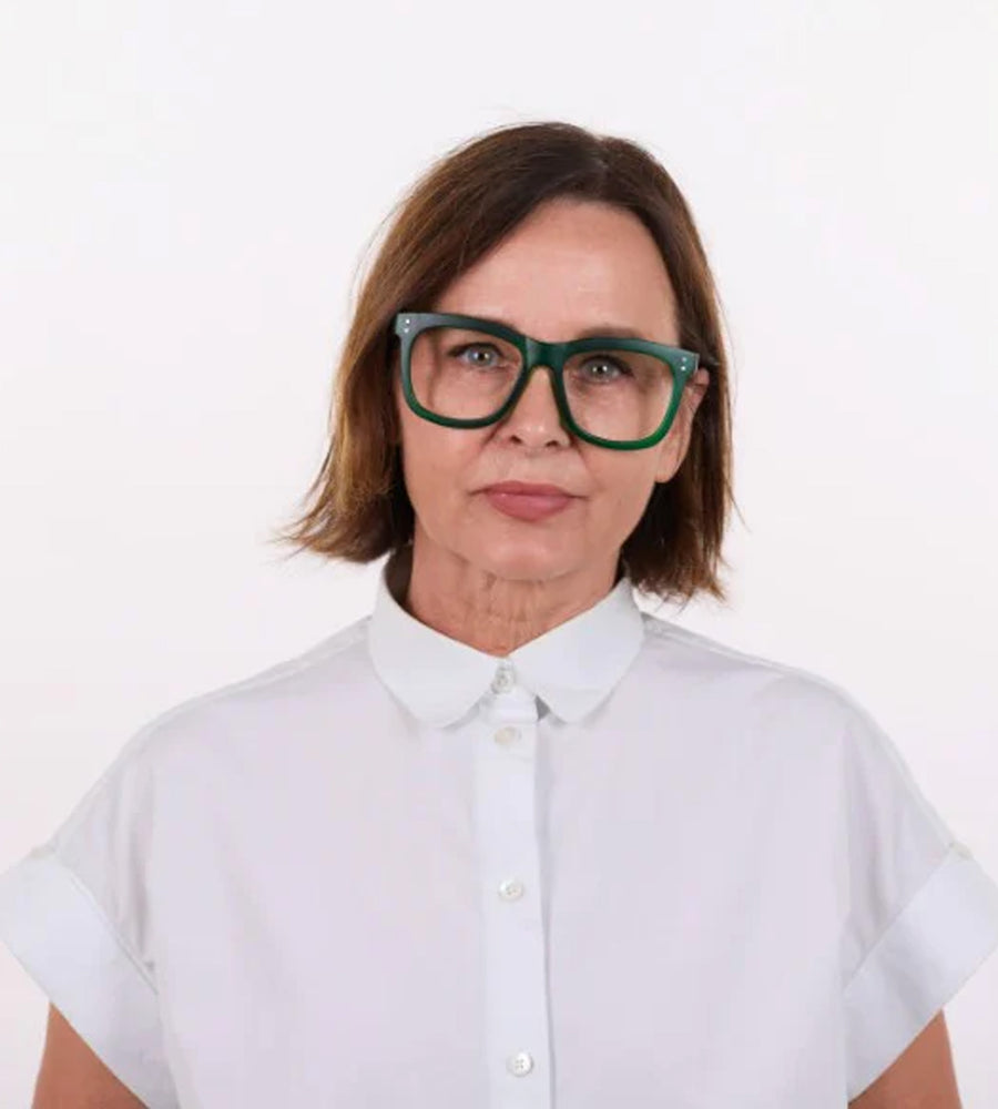 Person wearing a white shirt and green glasses on a white background