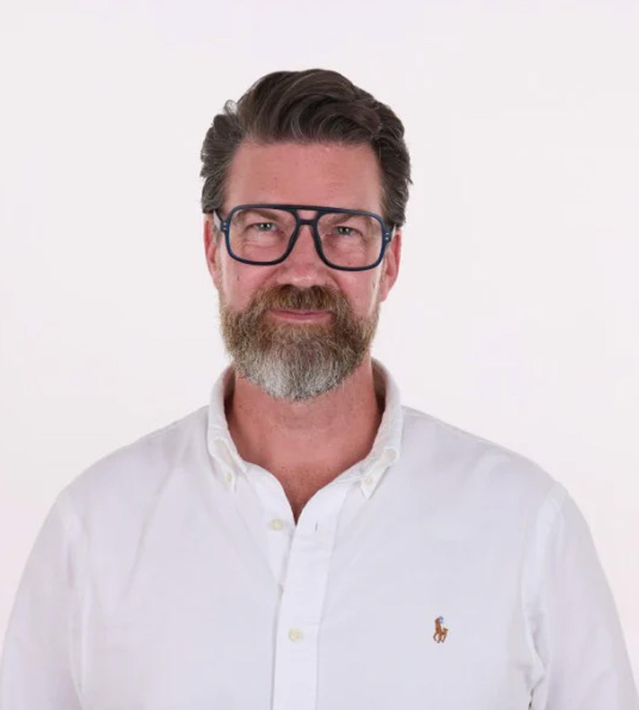 Man wearing glasses and a white shirt with a logo on a white background
