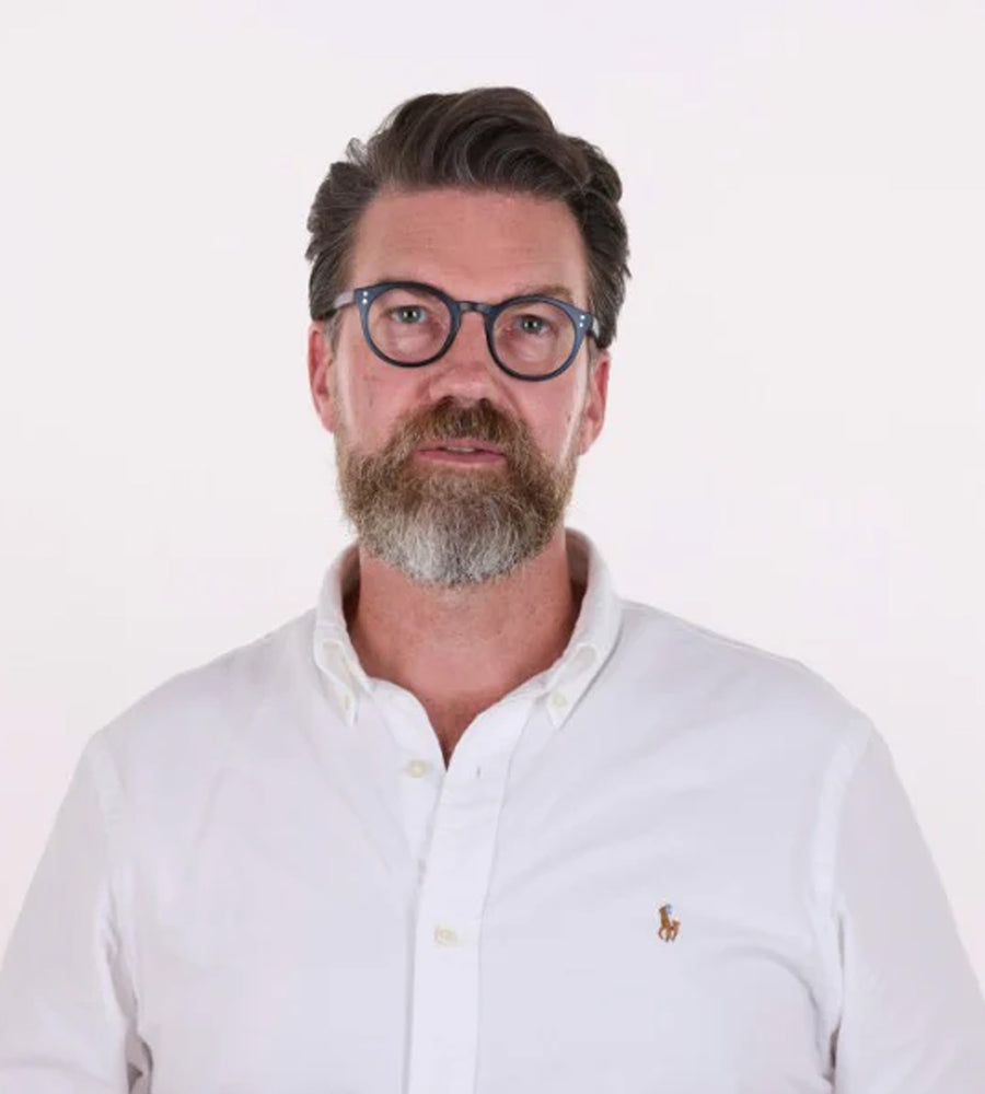 Man wearing glasses and a white shirt with a logo on a white background