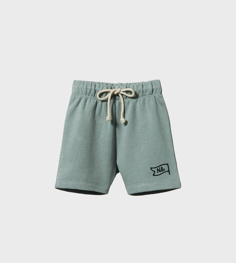Green shorts with a logo on a light gray background