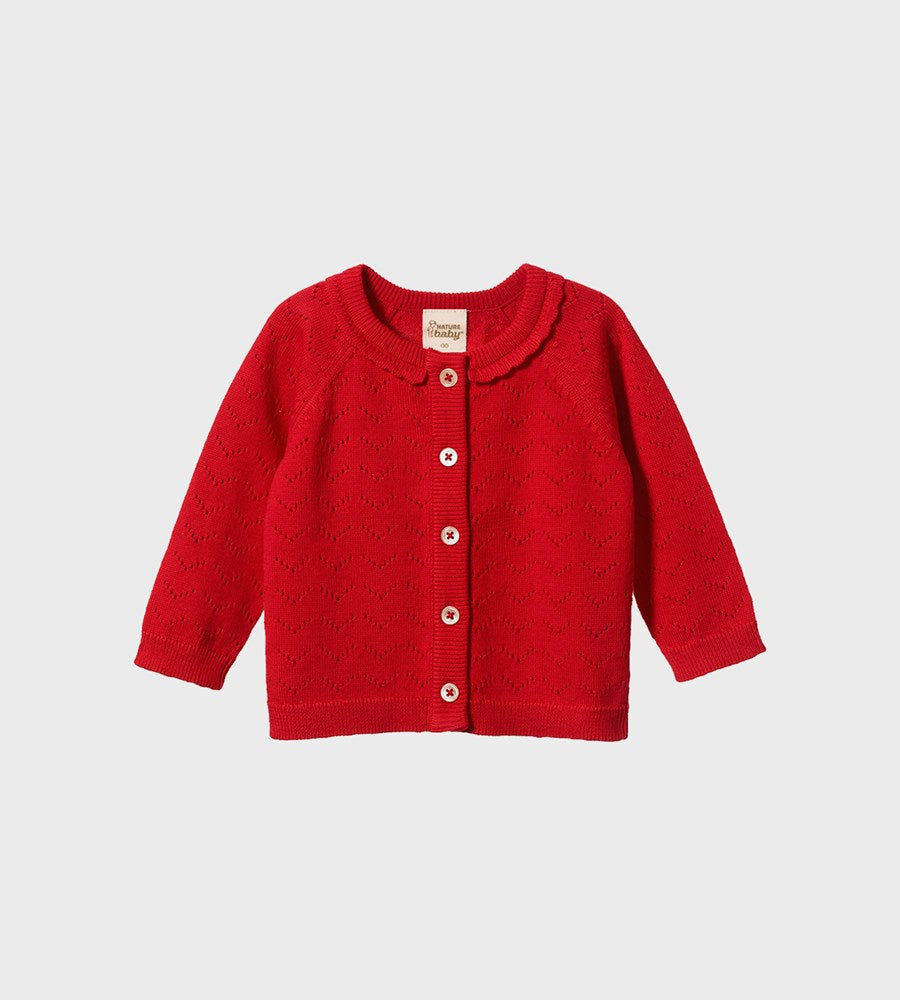Red baby cardigan with button details on a light gray background