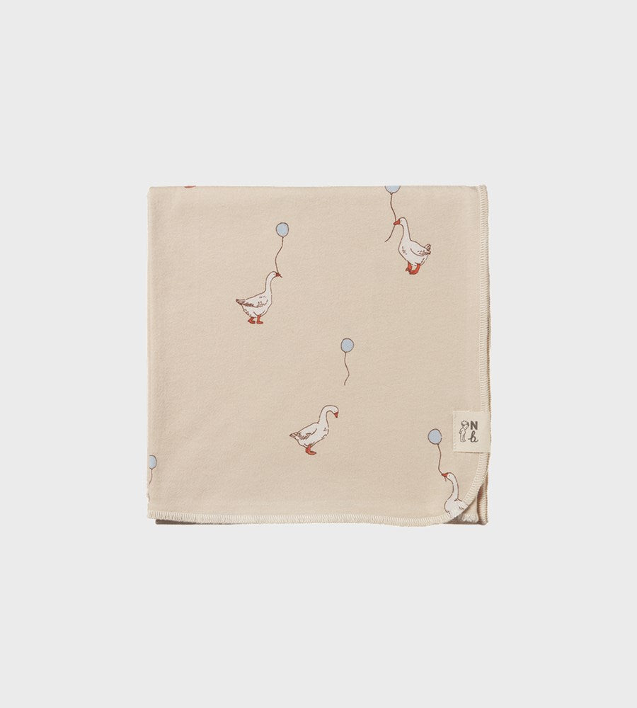 Beige blanket with duck and balloon pattern on a white background