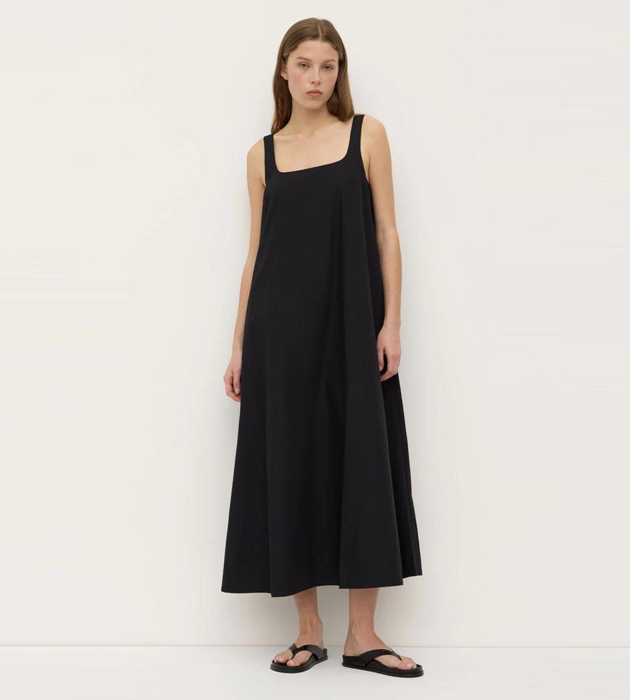 Woman wearing a black sleeveless dress against a white background
