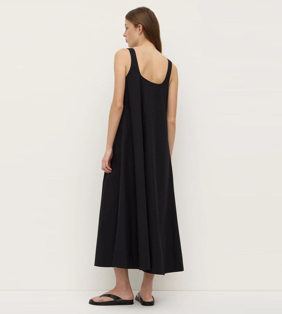 Woman wearing a black sleeveless dress against a white background