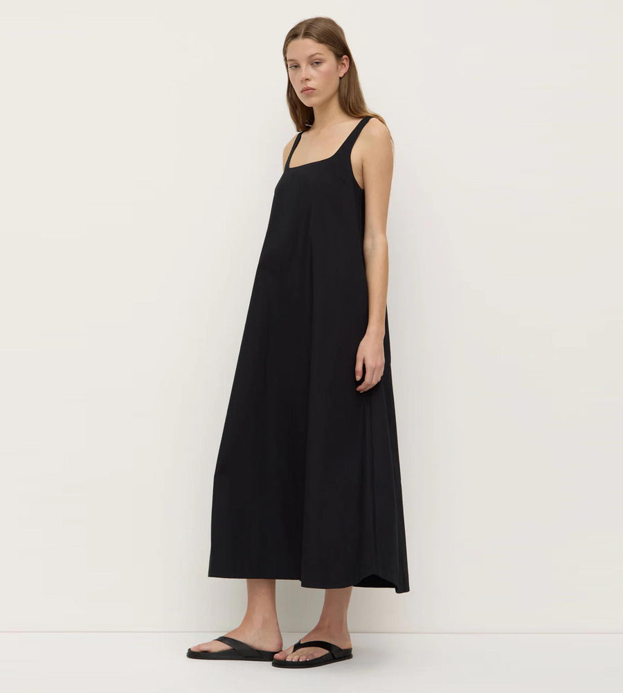 Woman wearing a black slip dress against a white background