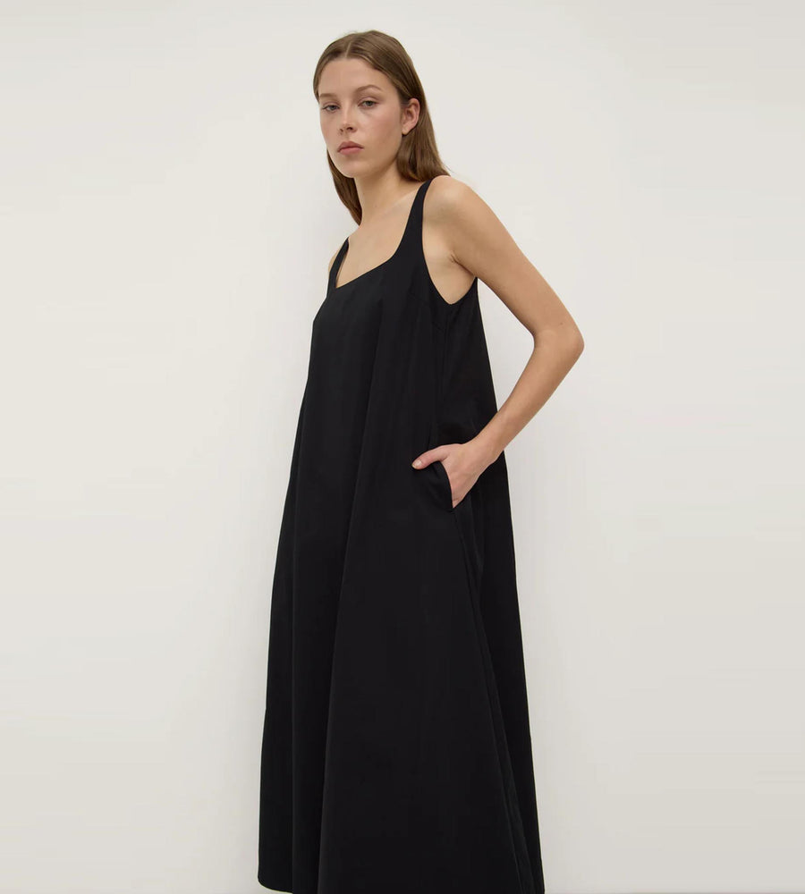 Woman wearing a black dress against a white background