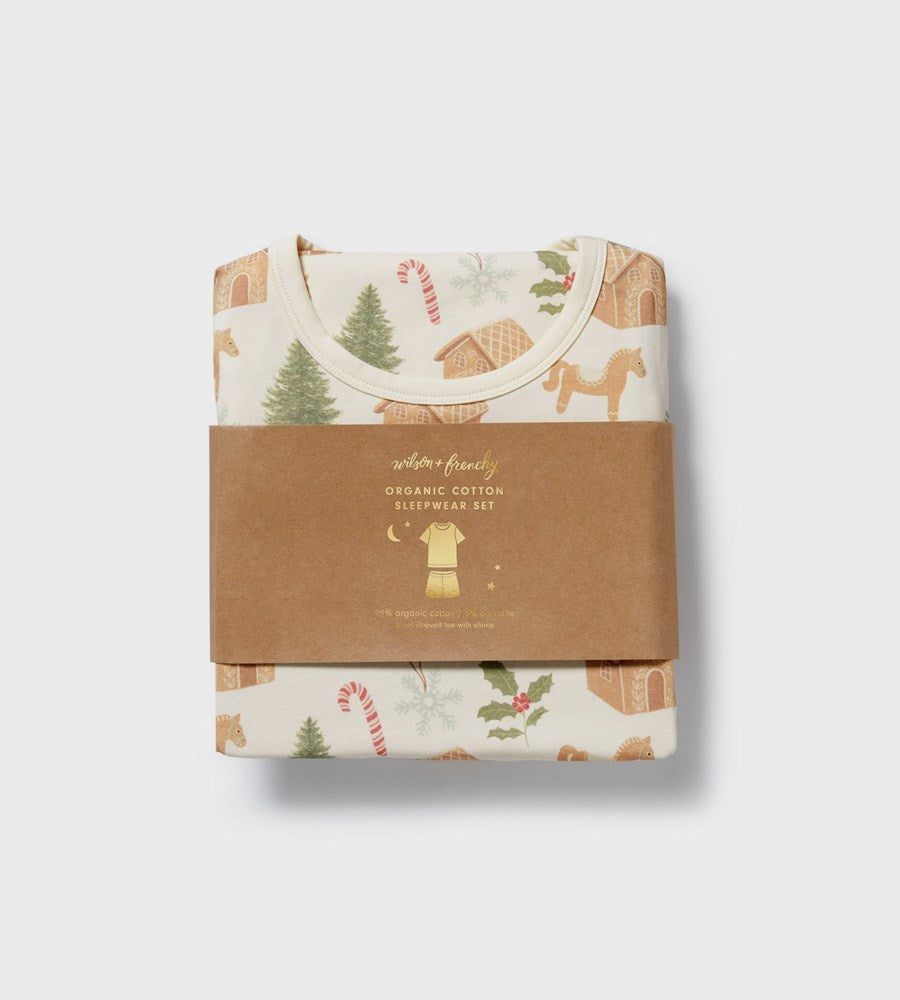 Packaged organic cotton baby clothing set with festive design on a light gray background