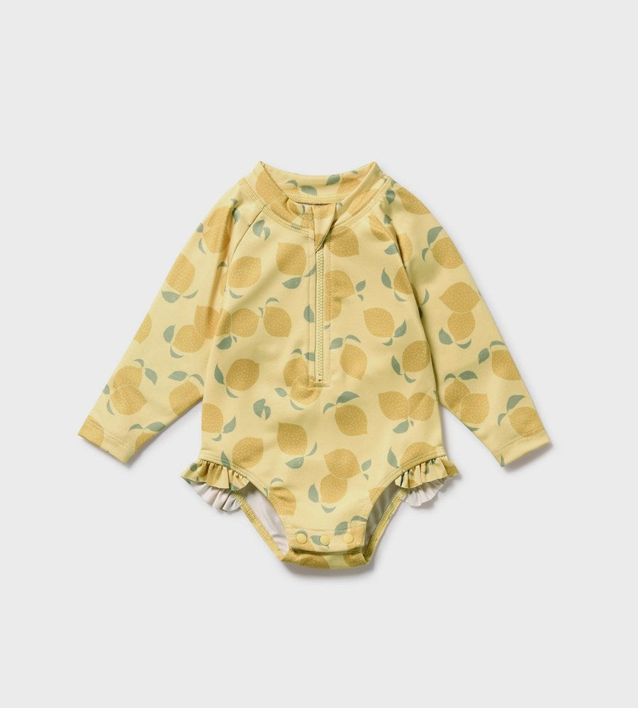 Yellow baby onesie with leaf pattern on a light gray background