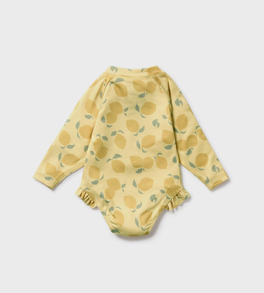Yellow baby onesie with lemon pattern on a light gray background