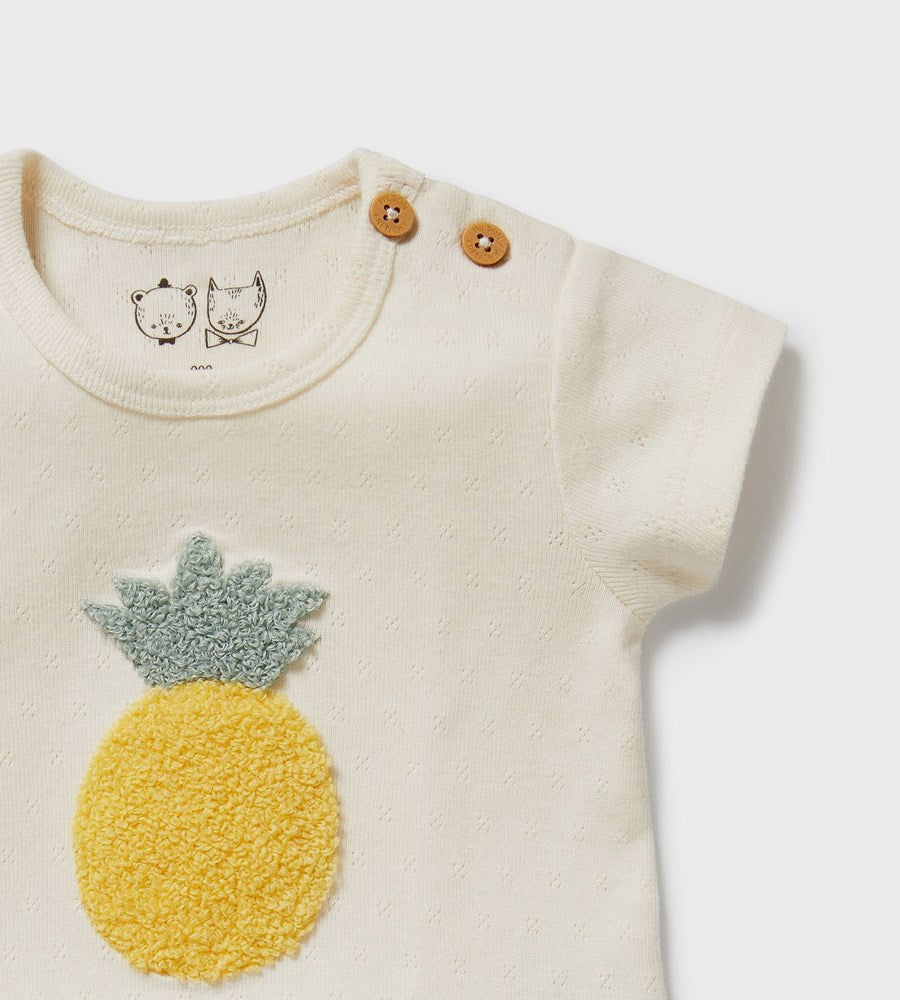 Baby onesie with a pineapple design on a white background
