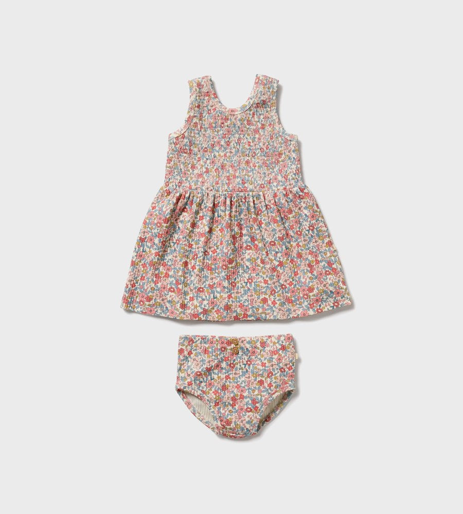 Floral baby dress and bloomers set on a light gray background