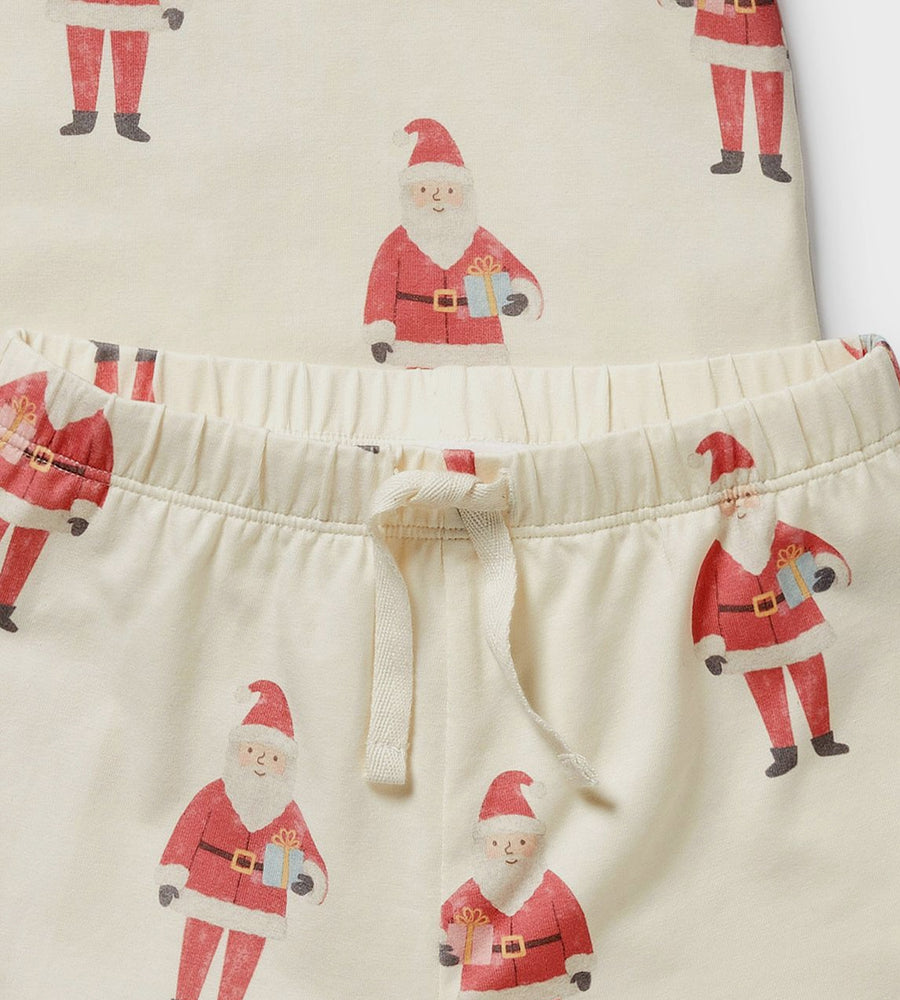 Close-up of pajama pants with Santa Claus pattern on a cream background