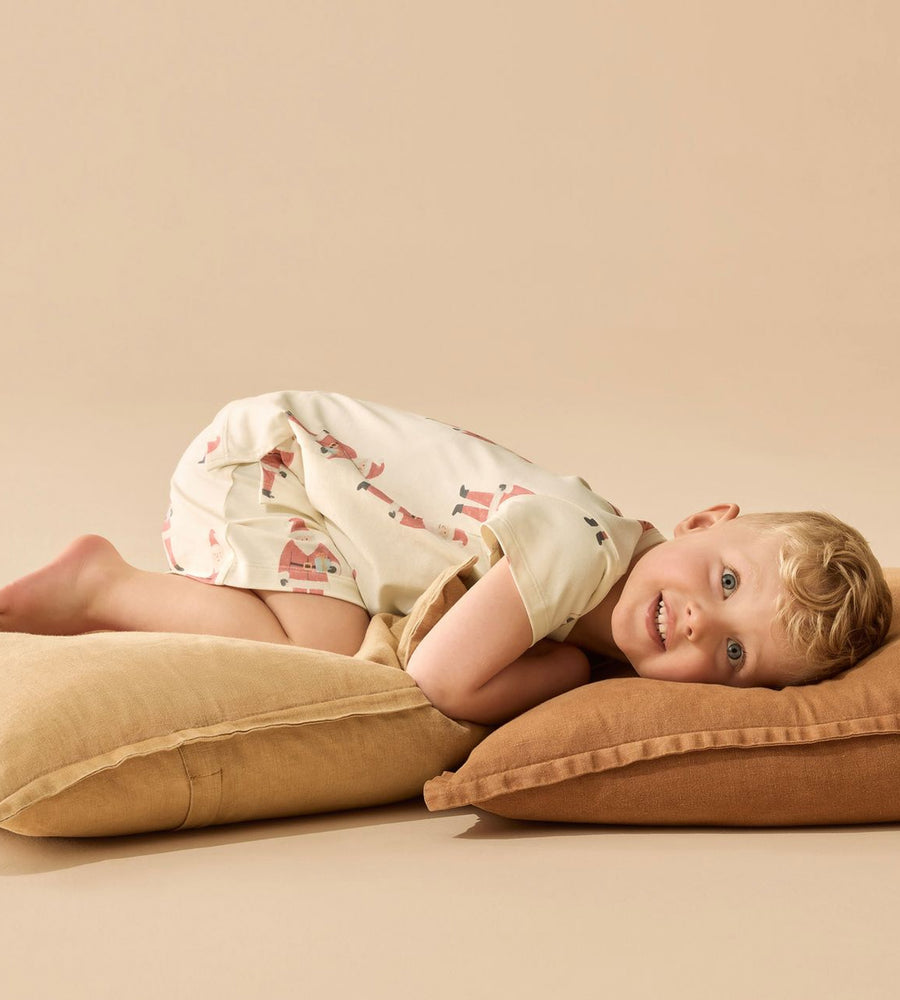 Child lying on a brown pillow against a beige background