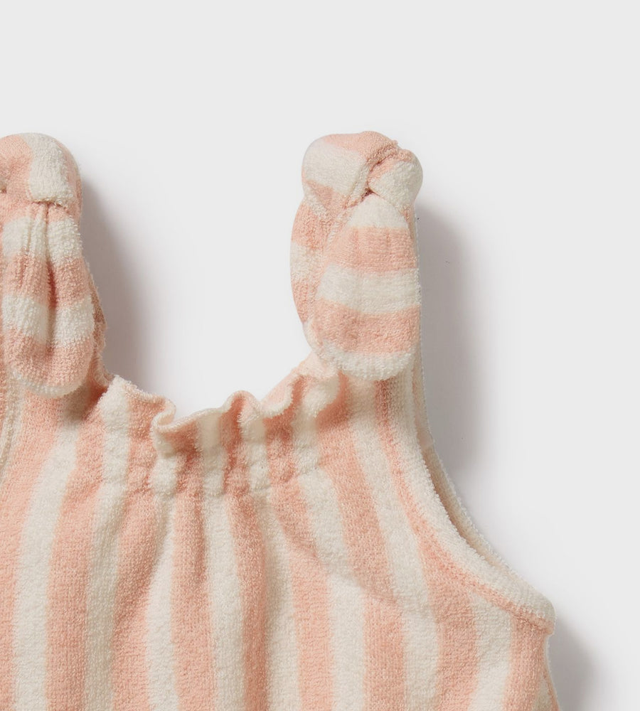 Striped baby romper with bow straps on a light background