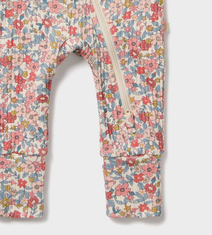 Floral patterned baby romper with a zipper on a white background